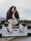 a dog laying on top of a collapsed white collapsible dog crate with their paws hanging over the edge