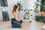 girl in her modern home, looking at her dog inside of a white collapsible dog crate